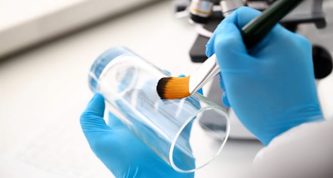 Male hand in blu protective gloves hold brush. Criminal investigation concept