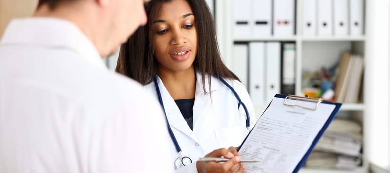 Female doctor hand hold silver pen and showing pad. Physical agreement form signature disease prevention ward round reception consent contract sign prescribe remedy healthy lifestyle concept