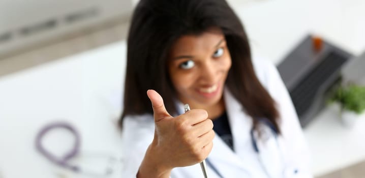 Female black doctor show OK or approval sign with thumb up portrait. High level service, best treatment 911 healthy lifestyle satisfied patient therapeutist consultation physical concept