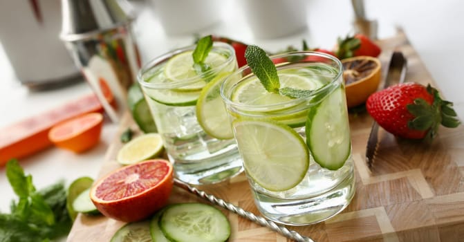 Lime with cucumber punch home made cocktail closeup on wood background