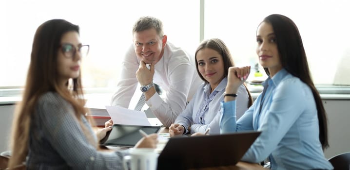 Portrait of cheerful businesswoman and businessman discussing annual report. Perfect woman and man looking at camera with gladness. Business company and teamwork concept
