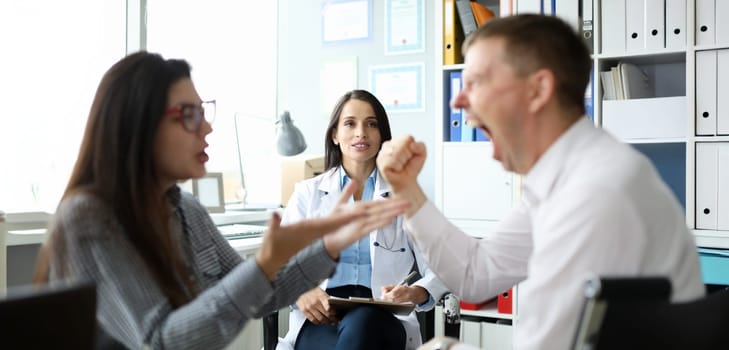 Portrait of cheerful specialist looking at visitors. Married couple listening good news. Surprised woman looking at man screaming with joy. Family planning center concept