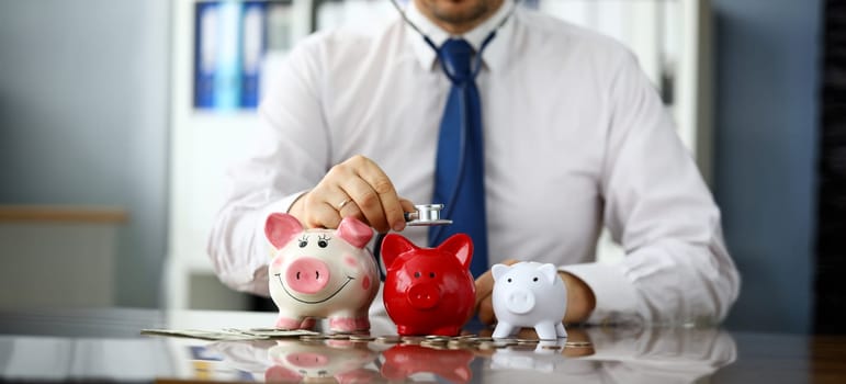 Businessman in tie listen three piggybanks for cash close-up. Business partners searching concept