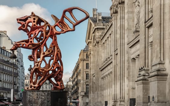 France, Paris - Jan 05, 2024 - Side view of the Angel Bear red sculpture made (A piece of contemporary art) by the artist Richard Texier in front of the main Gare du Nord or Paris train station.
