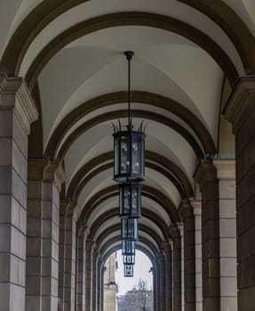 Munich, Germany - Dec 21, 2023 - Perspective view of Stone archway walkway with lanterns outside the ballroom of the The Munich Residence building. Architectural structure in Renaissance baroque style, Copy space, Selective focus.
