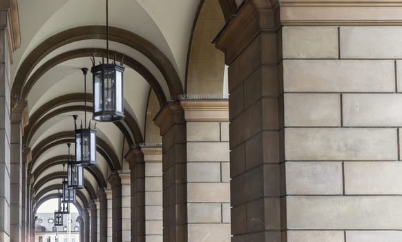 Munich, Germany - Dec 21, 2023 - Perspective view of Stone archway walkway with lanterns outside the ballroom of the The Munich Residence building. Architectural structure in Renaissance baroque style, Space for text, Selective focus.