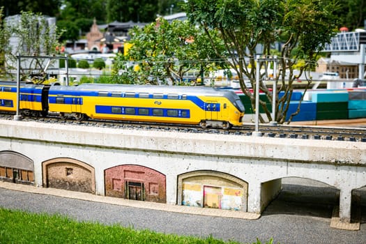 the haque,holland,09-07-2024:Toy dutch train over the bridge over the river in a miniature city in Madurodam park, Netherlands.