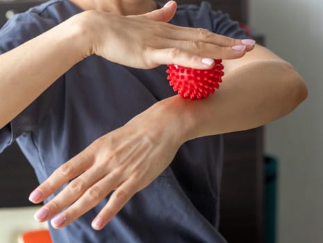 Shot of the female doctor manual therapist holding portable massage ball, Showing how to apply pressure with it
