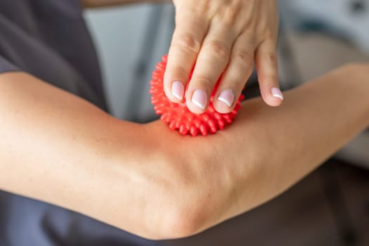 Shot of the female doctor manual therapist holding portable massage ball, Showing how to apply pressure with it