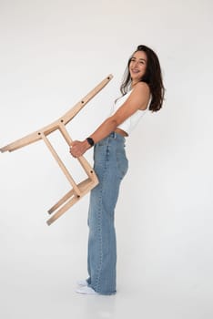 Happy beautiful girl posing in a new hot summer look. Wearing blue jeans and white waistcoat.