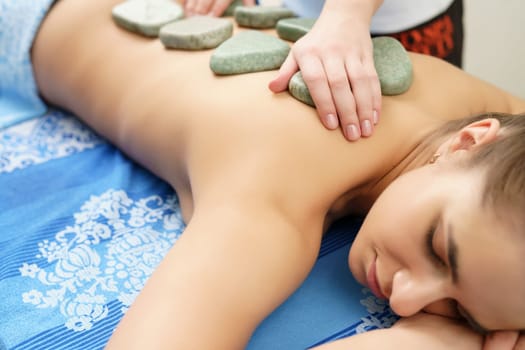 Spa massage. Image of young girl lying on her stomach
