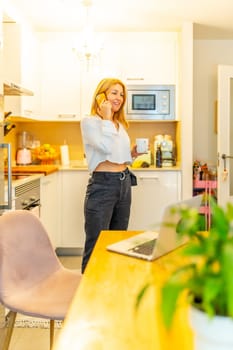 Vertical full length photo of a mature caucasian blonde casual woman in a business call working from home