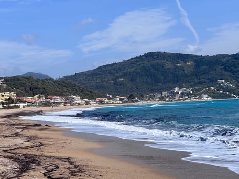 A beautiful landscape of the coast of the island of Corfu in the Ionian Sea of the Mediterranean in Greece. Pure blue clear water washes over the shores of the Greek island. High quality photo