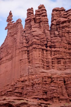 Two rock climbers ascend the red rock formations of Fisher Towers in Moab, Utah. The dramatic landscape and tall spires create a sense of adventure in this popular rock climbing destination - USA