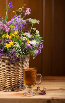 Bouquet of medicinal herbs and herbal tea on a wooden background