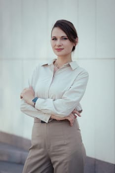 Business portrait of caucasian young woman in office or business style in clothes in beige tones with a smart watch.