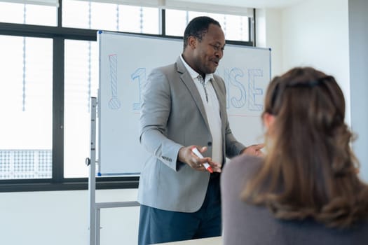 Mature professor talking to his student while assisting her on a class at the university.