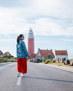 Texel lighthouse during sunset Netherlands Dutch Island Texel Holland, Asian woman visit the lighthouse during vacation at the Dutch Island Texel