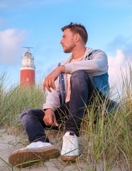 Texel lighthouse during sunset Netherlands Dutch Island Texel Holland, men on vacation at the Dutch Island Texel