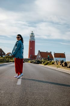 Texel lighthouse during sunset Netherlands Dutch Island Texel Holland, Asian woman visit the lighthouse during vacation at the Dutch Island Texel during summer
