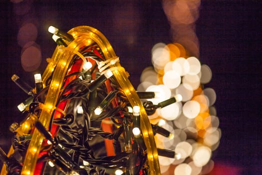 Occasional glowing Christmas and New Year decorations hang in the square, shot at night
