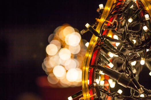 Occasional glowing Christmas and New Year decorations hang in the square, shot at night
