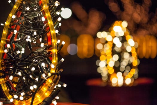 Occasional glowing Christmas and New Year decorations hang in the square, shot at night
