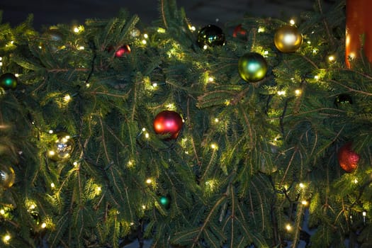 Occasional glowing Christmas and New Year decorations hang in the square, shot at night
