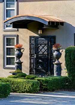 Metal grid door of a residential house with lightweight cover over the entrance.