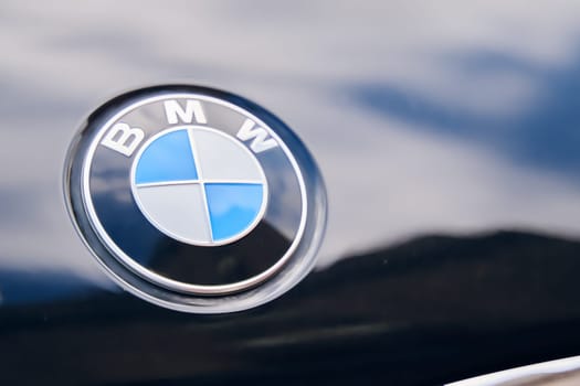 A detailed close-up showcasing the BMW logo on the vehicle's hood. BISHKEK, KYRGYZ REPUBLIC - 19 AUGUST 2021