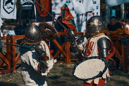 Knights in armor, helmets, with shields and swords. Reconstruction of jousting tournaments. Festival of historical clubs in the Park. Bishkek, Kyrgyzstan - October 13, 2019