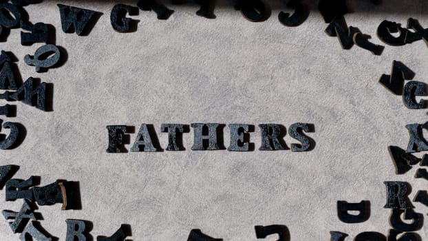 Lettering father in black letters on grey background on father's day close-up