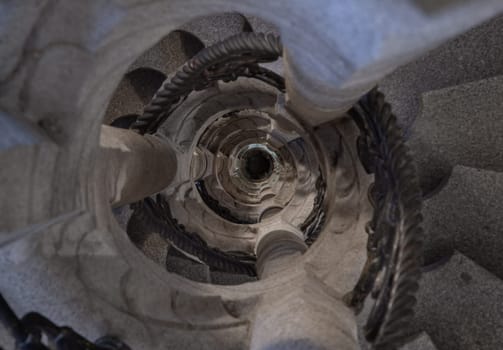 Munich, Germany - Dec 21, 2023 - Upside view of The old stone spiral staircase with iron railing inside columnar structures. Ladder decoration interior of building, Space for text, Selective focus.