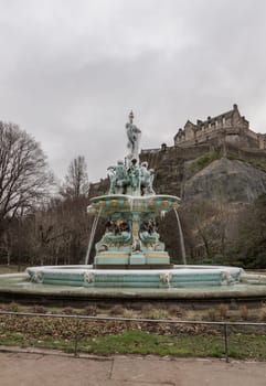 Edinburgh, Scotland - Jan 16, 2024 - Scenic view of Ross Fountain with Edinburgh Castle at the top of the hill at West Princes Street Garden in the centre of Edinburgh. is one of the most popular tourist attractions in Edinburgh, Copy space, Selective focus.