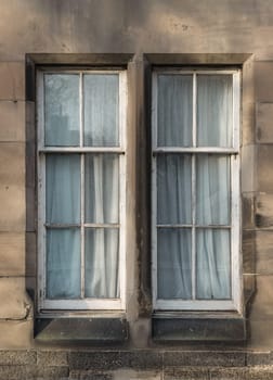 Edinburgh, Scotland - Jan 19, 2024 - The sunshine lights through the glass window frame exterior of old house. Glass window and old wall in Edinburgh, Space for text, Selective focus.