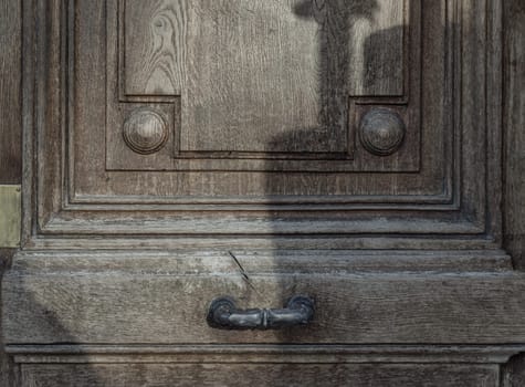 Metal door handle on Brown old wooden door. Traditional wooden entrance door with Old metal door handle, Space for text, Selective focus.