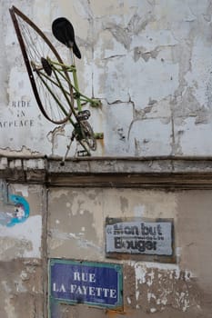 France, Paris - Jan 03, 2024 - Ride in Peace on rue la fayette. Sculptures bicycle art installed on wall decor old building, Urban intervention art, Paris street artwork, Paris wall art, Space for text, selective focus.