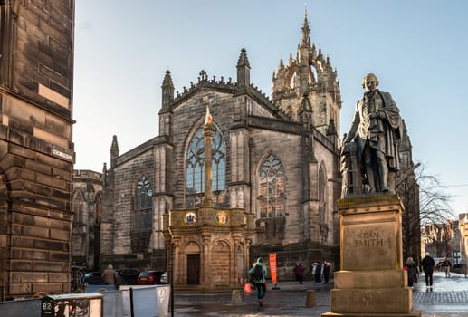 Edinburgh, Scotland - Jan 18, 2024 - The monument bronze statue of Adam Smith in front of St Giles' Cathedral or the High Kirk of Edinburgh. Space for text, Selective focus.