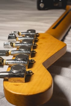 Close up from a Headstock of a guitar made of Maple wood, and some silver color tuners.