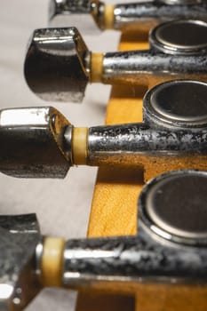 Close up from a Headstock of a guitar made of Maple wood, and some silver color tuners.