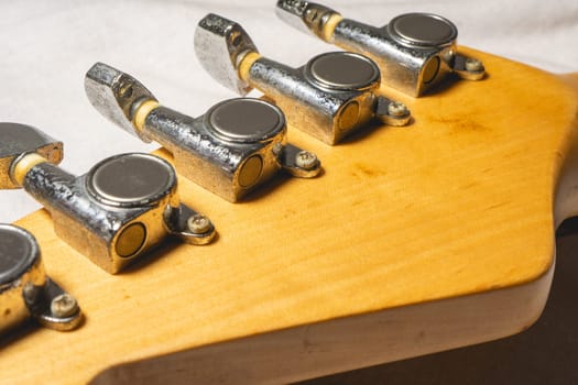 Close up from a Headstock of a guitar made of Maple wood, and some silver color tuners.