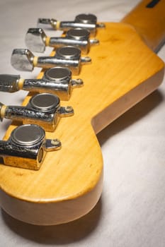 Close up from a Headstock of a guitar made of Maple wood, and some silver color tuners.