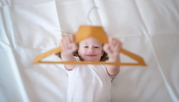 Portrait of little kid having fun in bed at home. Small child resting after active boy. Happy childhood concept