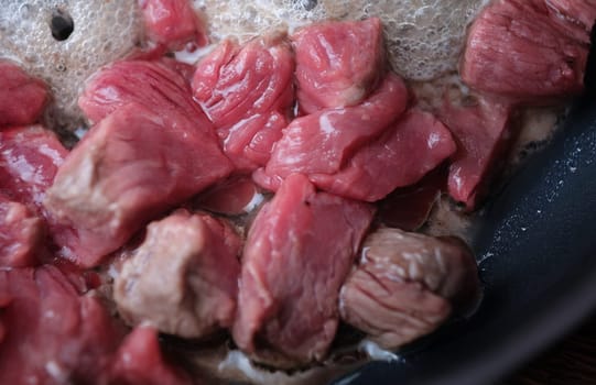Top view of pieces of pork fried in pan, traditional meat dish. Hungarian goulash or pork stew. Cooking food concept