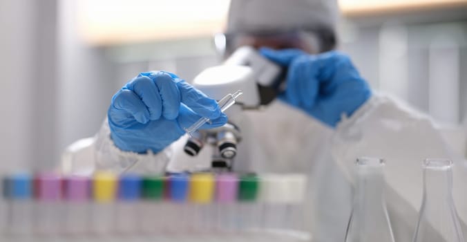 Close-up of scientist in laboratory holding syringe with liquid vaccines. Pharmaceutical bio research. Vaccine development program