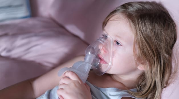 Portrait of sick little child in medical oxygen mask lying in bed. Labored breathing and lack of oxygen or inhalation concept
