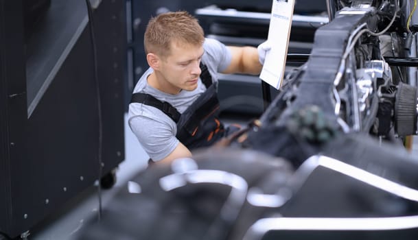 Portrait of concentrated male mechanic work with tool, fix damaged motorbike at workshop. Mechanic repair old detail. Pit stop, service help, maintenance concept
