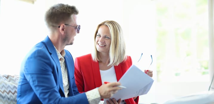 Portrait of smiling businessman and businesswoman discussing good deal. Realtor and client signing lease contract. Bargaining concept