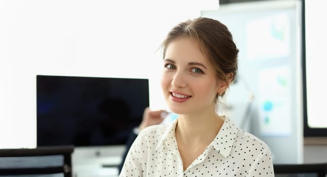 Portrait of smiling woman posing in corporate modern office. Cheerful looking at camera with happiness. Woman posing in meeting room