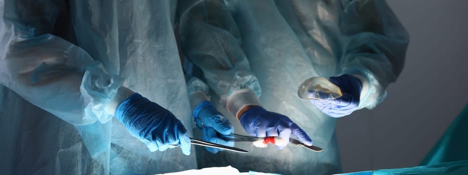 Close-up of operating tools and chest implants in surgery room. Implantation process. Surgical intervention, plastic surgery and breast augmentation concept